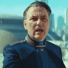 a man in a blue uniform is making a funny face with his mouth open