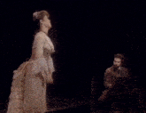 a woman in a corset with ruffled sleeves is standing in front of a mirror