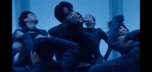 a group of people are dancing in a dark room in a dark room .