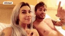 a man and a woman are laying on a bed and the man is naked .