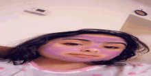 a girl wearing a purple face mask with a thermostat in the background