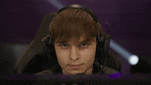 a man wearing headphones and a microphone looks down at something