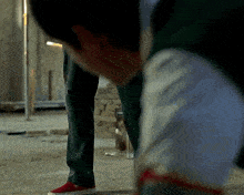 a man in green pants and red shoes is kneeling down