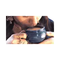 a woman is drinking from a blue striped mug