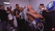 a group of men are standing in a room with a referee and a wrestler wearing a blue mask with the number 3