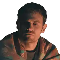 a man is wrapped in a plaid blanket and looking at the camera