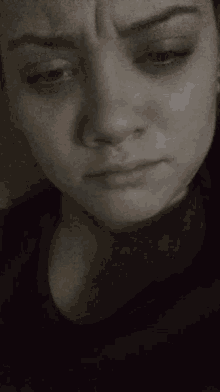 a close up of a woman 's face with white eyes looking up