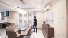 a woman stands in a dining room with the words made in animatica on the bottom