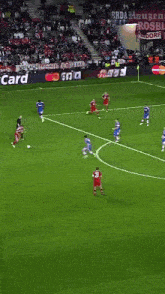 a soccer game is being played on a field that has adidas advertisements on the sidelines