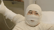 a person with a bandage on their face is laying in a hospital bed