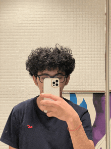a man in a hollister shirt takes a selfie with his phone