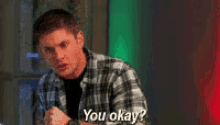 a man in a plaid shirt is asking if he 's okay .