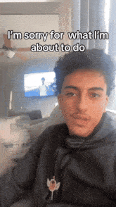 a young man sitting on a couch with the caption i 'm sorry for what i 'm about