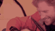 a close up of a man wearing a red jacket that says ' sns ' on it