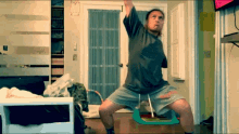 a man in a superman shirt is doing a yoga pose in a room