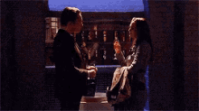 a man and a woman are standing next to each other in a dark room .