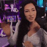 a woman wearing headphones talks into a microphone in front of a shelf full of oreos