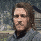 a man with a beard and long hair is looking at the camera .
