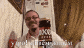 a man is holding a bottle of oxo kpeni