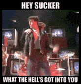 a man singing into a microphone with the words hey sucker what the hell 's got into you underneath him