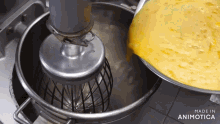 a mixer is being used to mix a yellow substance and the words made in animotica are on the bottom