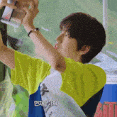 a person taking a picture of another person with korean writing on the bottom right