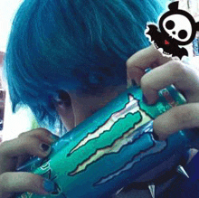 a person with blue hair is holding a monster energy drink can