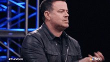a man in a leather jacket is clapping his hands in a nbc ad