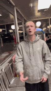 a man in a nike hoodie is standing in a diner .