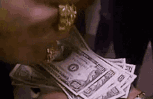 a person is holding a stack of money in their hand .