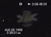 a black and white photo of a mickey mouse sitting on a table with the date august 29 1999 .