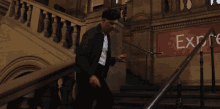 a man is walking down stairs in front of a sign that says " exp "
