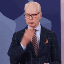 a man in a suit and tie is making a gesture .