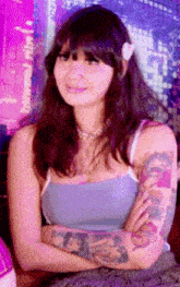 a woman with a flower in her hair and a tattoo on her arm