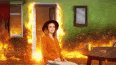 a woman is sitting in front of a fire in a burning room .