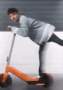 a man is riding an orange scooter that says pure