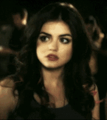 a close up of a woman 's face with a crowd in the background