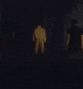 a group of people are standing on a stage in a foggy room