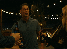 a group of people are standing around a man in underwear who is pouring beer on him