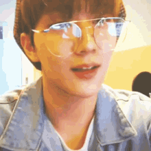 a close up of a person wearing glasses and a blue jacket