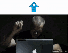 an older man sitting in front of an apple laptop