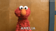elmo from sesame street is talking to a woman named amelia .
