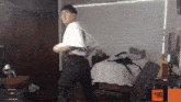 a man in a white shirt is dancing in a room with balconi written on the bottom of the screen
