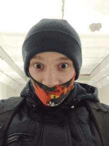 a person wearing a beanie and a scarf around their neck has a surprised look on their face