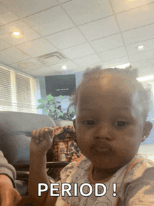 a baby is sitting in a chair with the word period written on the bottom