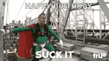 a man in a superhero costume is flying through the air while saying `` happy birthday suck it '' .