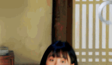 a close up of a woman 's face in front of a window