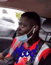 a man in a car wearing a mask and a shirt that says mood on it