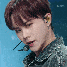 a close up of a man wearing a microphone with kbs written on the bottom