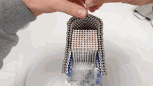 a person is holding a stack of metal beads in their hands